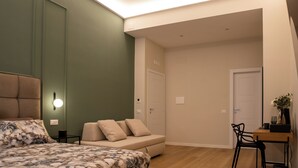 Una camera da letto con un letto, una poltrona, una scrivania e una sedia.
