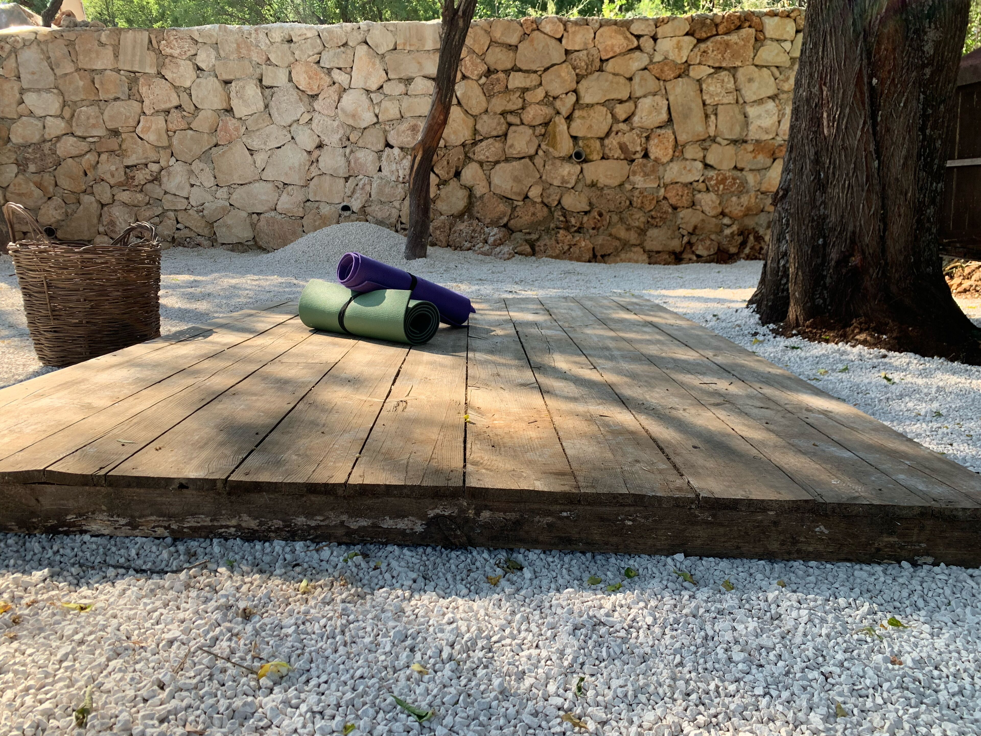 Une terrasse en bois avec un mur de pierre en arrière-plan.