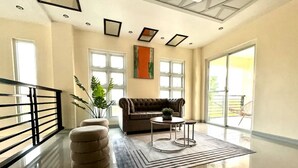 A spacious living area with a modern sofa, a round coffee table, and a large window providing natural light. - GREAT PLACE TO STAY (San Nicolas)