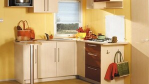 A compact kitchen with a window, a stove, and cabinets.