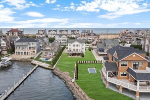 A coastal residential area with houses, a dock, and a grassy lawn. - Mantoloking Bay Side Escape  (Mantoloking)