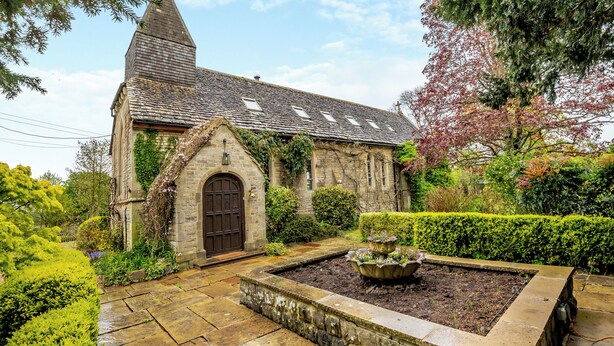 A stone building with a pointed roof and a central arched entrance. - 4 bedroom accommodation in Hilmarton, near Calne (Hilmarton, near Calne)