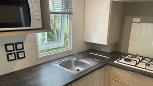 A modern kitchen with a built-in microwave, a stainless steel sink, and a gas stove.