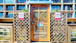 Uma entrada com portão e placas que indicam acesso exclusivo para moradores das Cabanas.