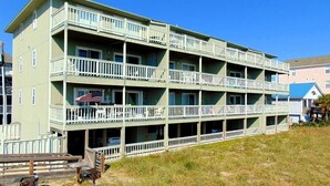 A multi-story hotel with balconies, a flag, and a beach view. - Sands 4 3-A-2 bedroom 2 bath, 3rd floor condo with sweeping views from the Master and living room (Carolina Beach)