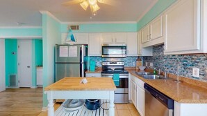 A kitchen with white cabinets, a stainless steel refrigerator, a microwave, an oven, and a dishwasher. - Salty Shamrock, modern and spacious 2 bedroom, 2 bathroom condo, with ocean views (Carolina Beach)