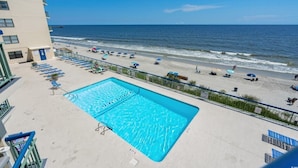 A rooftop pool with a view of the beach and ocean.