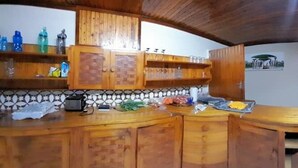 Eine Küche mit Holzausstattung, einer Arbeitsplatte und Blick ins Freie.