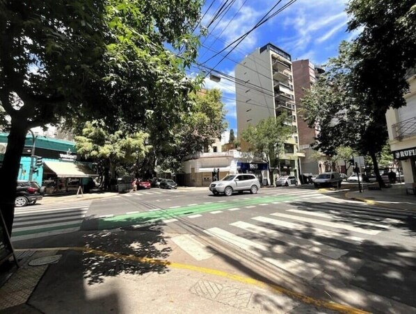 A street view with a crosswalk, parked cars, and buildings including a bank and a restaurant.