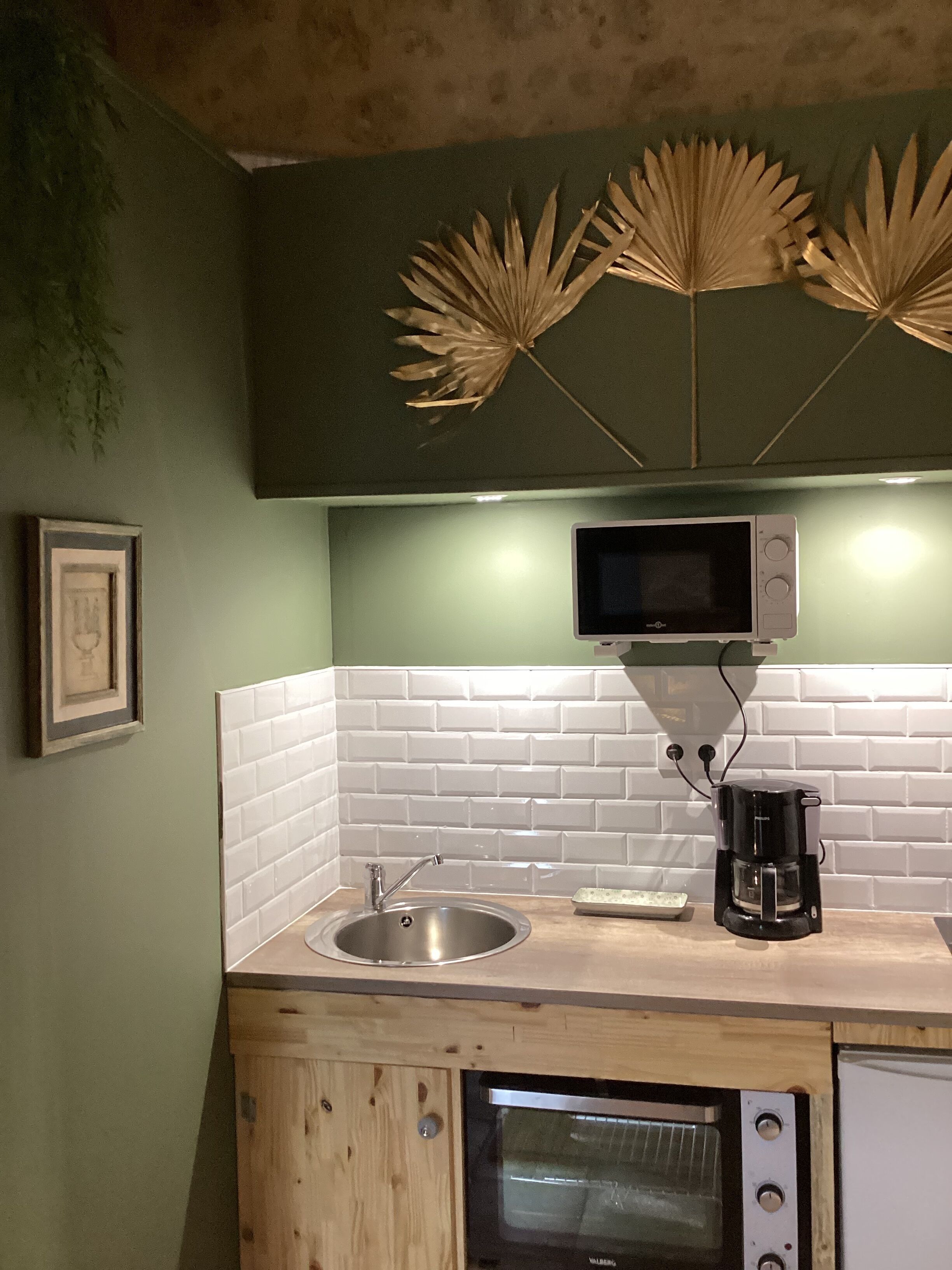 A kitchen with a sink, microwave, coffee maker, and oven.