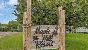 Un letrero de madera para Maple Hill Resort, con un diseño sencillo y rústico.