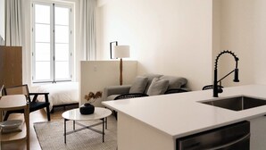 A modern, well-lit room with a kitchen area, a dining table, and a sofa. - Maison Place Jacques-Cartier • Luxury Loft • Old Montreal • Self Check-In Access • Full Kitchen • Wi-Fi • AC (Montréal)