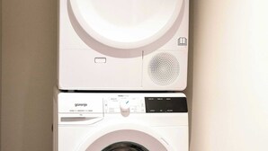 A white wall-mounted washing machine with a control panel and a dryer stacked on top. - Maison Place Jacques-Cartier • Luxury Loft • Old Montreal • Pet Friendly • Full Kitchen • Wi-Fi • AC (Montréal)