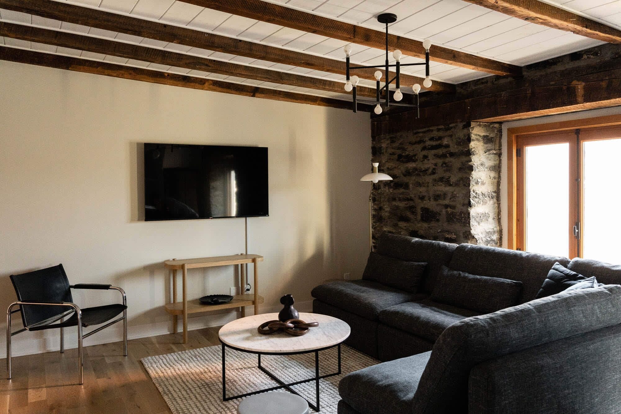 A living room with a television, a sofa, a coffee table, a chair, and a lamp.