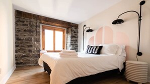 A bedroom with a bed, a window, a stone wall, and a lamp. - Maison Place Royale • Luxury Two-Bedrooms Apartment • Old Montreal • Full Kitchen • Stone Walls • Wi-Fi • AC (Montréal)