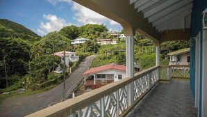 A balcony with a view of a hillside with houses and greenery. - Lovely entire new 2 Bedroom Apartment in Corinth (Gros Islet Castries)