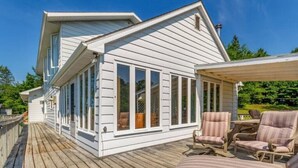 A white house with a covered deck and outdoor seating. - Jack's Lake Retreat - Perfect for multi-families! (Golden Valley)