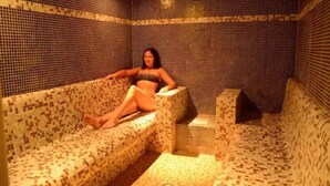 Una habitación con paredes de mosaicos y un sofá estampado.