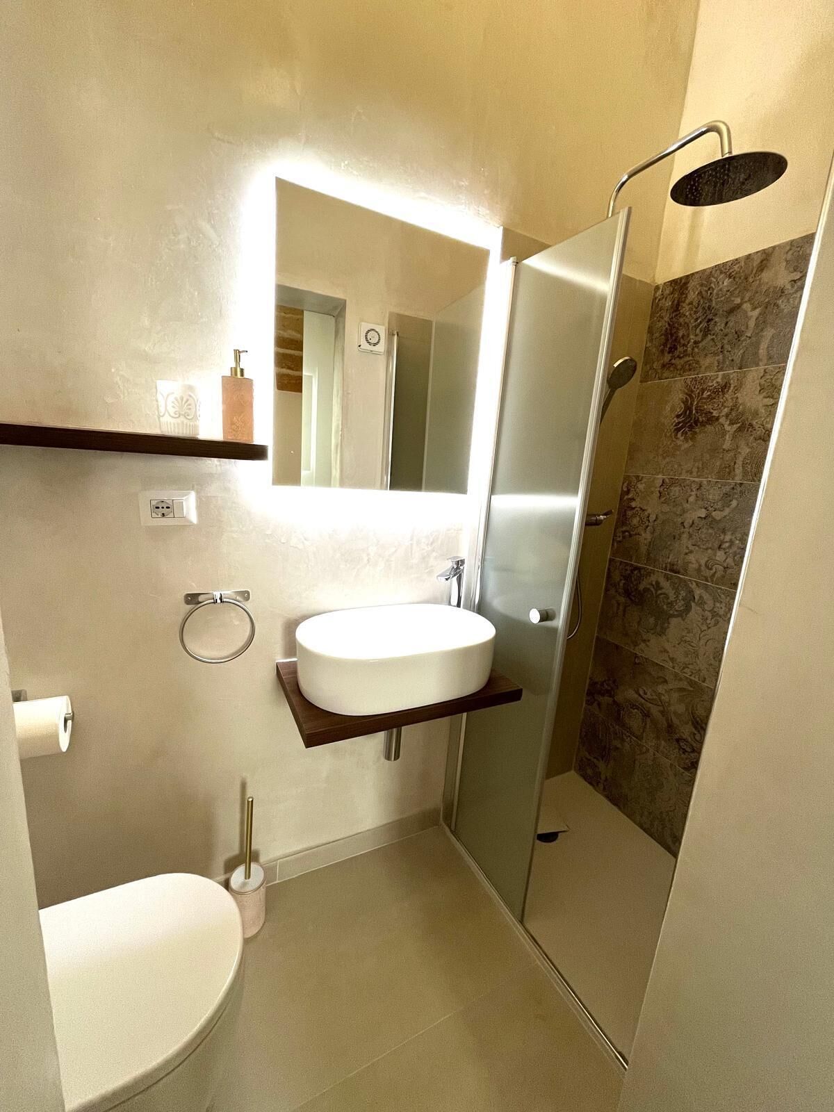 A modern bathroom with a toilet, sink, and shower.