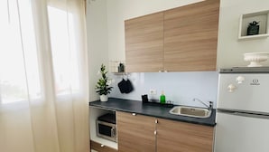 Eine moderne Küche mit Holzausstattung, einer schwarzen Arbeitsplatte, einer Edelstahl-Spüle und einem eingebauten Backofen.