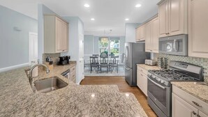A kitchen with granite countertops, stainless steel appliances, and light blue cabinetry. - Forest Landing Bethany Beach Pool, Kids Mega Room (Frankford)