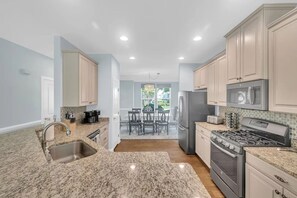 A kitchen with granite countertops, stainless steel appliances, and light blue cabinetry. - Forest Landing Bethany Beach Pool, Kids Mega Room (Frankford)