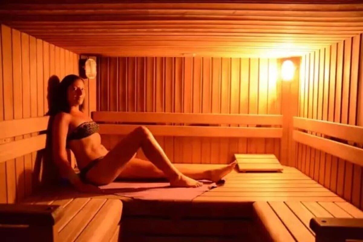 Una sauna con bancos de madera y un asiento tipo banca.