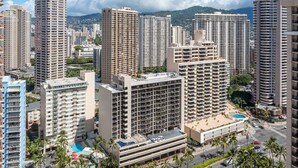 Un hotel di grandi dimensioni con numerosi piani, una piscina e un'area parcheggio.