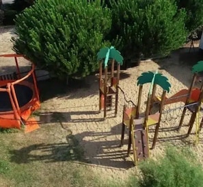 A playground with a swing set and climbing structures.
