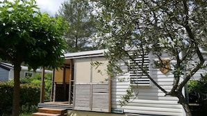 Una casa móvil con un pequeño porche y una ventana.