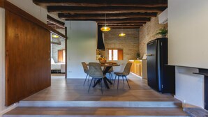 Une cuisine moderne avec un coin repas, un plancher en bois et des murs en briques apparentes.