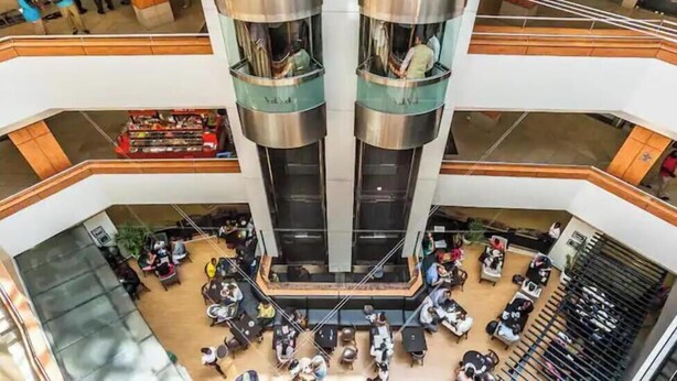 A multi-level atrium with a central open space surrounded by seating areas and a food court. - Skyview loft retreat Apartment, Smarthome Yaya (Nairobi)