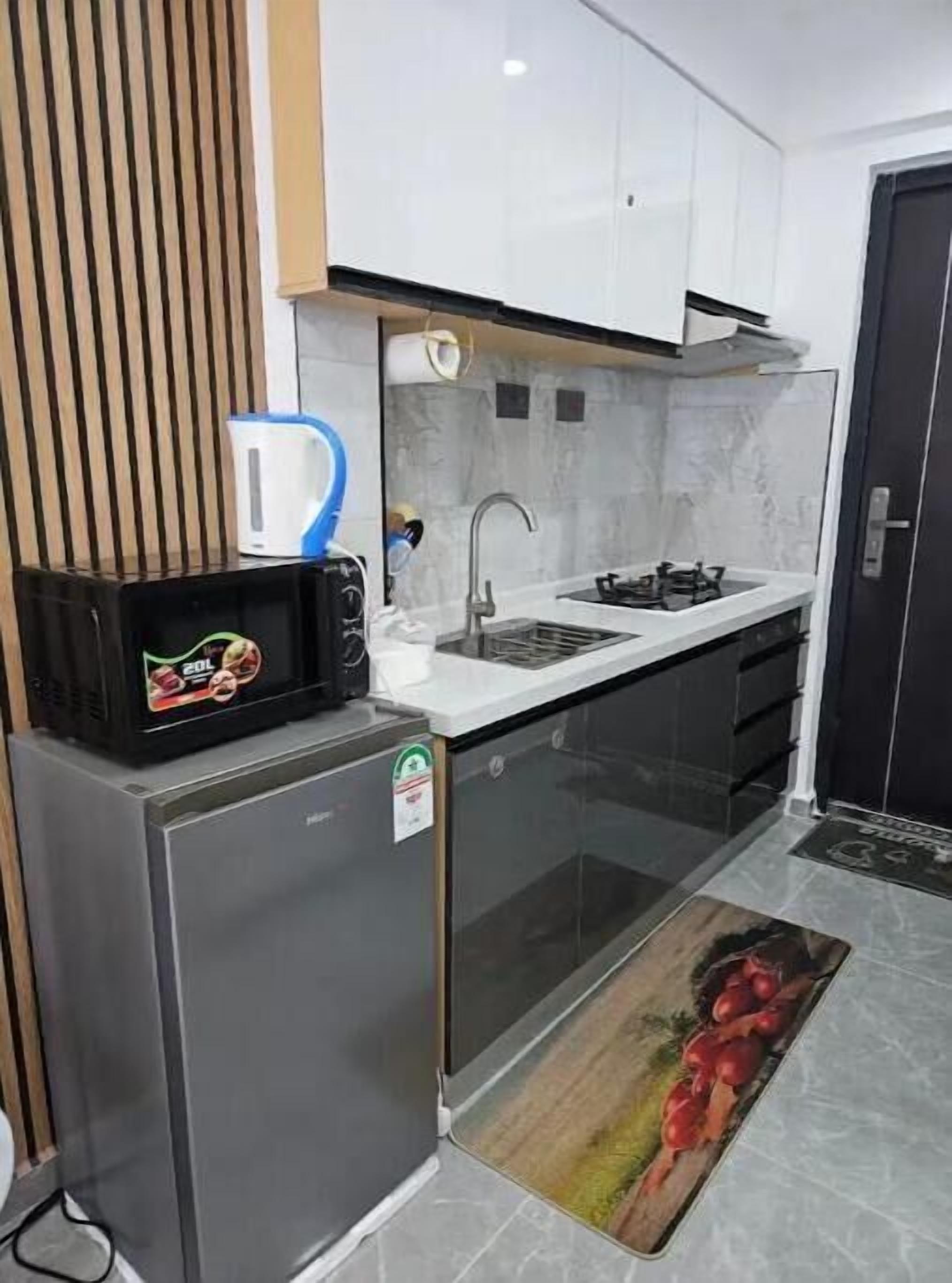 A compact kitchen with a built-in microwave, a sink, and a stove.