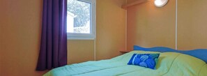 Simple, serene retreat with a single bed and natural light pouring in through the window.