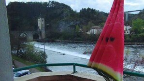 A wooden deck with a view of a river and a distant tower. - Le Petit Valentré Avec sa Superbe vue sur le Célèbre Pont et la Rivière Lot (Cahors)
