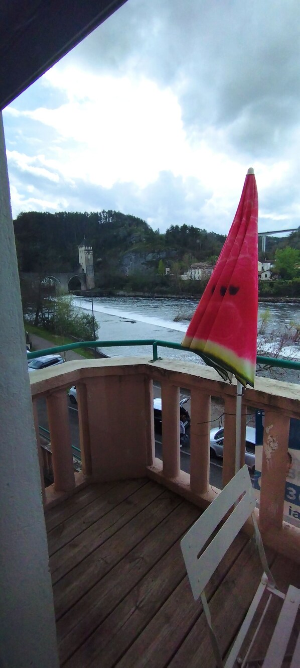 A wooden deck with a view of a river and a distant tower. - Le Petit Valentré Avec sa Superbe vue sur le Célèbre Pont et la Rivière Lot (Cahors)