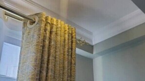 A bathroom with a shower curtain, a ceiling light, and a window.