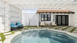 A poolside area with a white pergola, a small patio with a table and chairs, and a pool with clear water. - Design Award Winner Scottsdale/Tempe Home POOL HTD

 (Tempe)