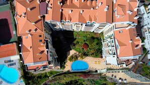 Une maquette d’un hôtel comprenant plusieurs étages, une cour intérieure avec une piscine et de nombreux espaces verts.