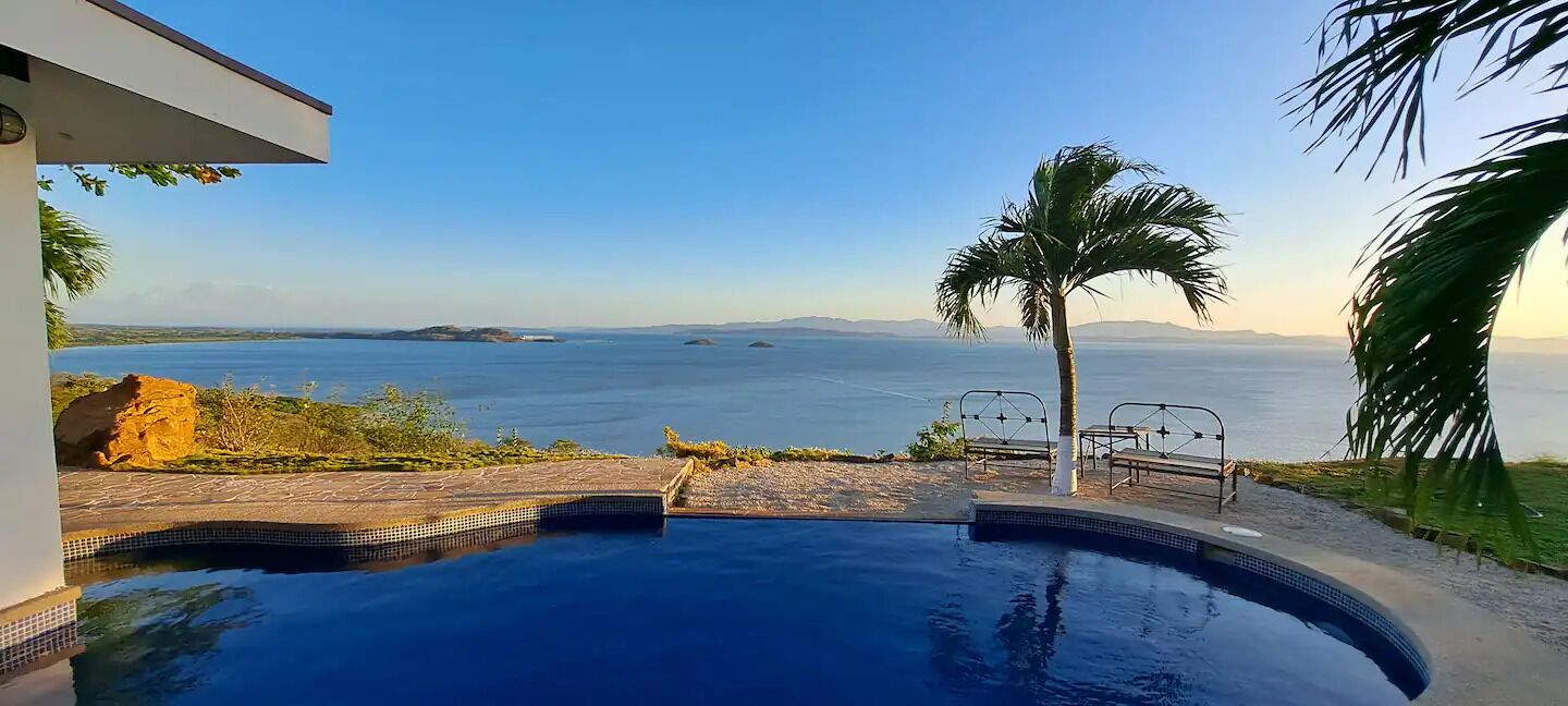 A swimming pool with a view of the sea and distant islands.