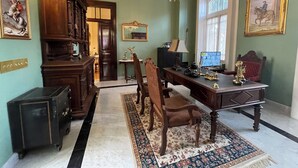 A formal room with a desk, chairs, a chandelier, and artwork on the walls. - Casa Chopo (Mexico City)