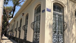 A building with arched windows and decorative iron railings. - Casa Chopo (Mexico City)