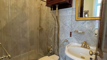 A bathroom with a shower, toilet, and sink.