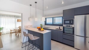 A modern kitchen with a marble countertop, stainless steel appliances, and a view of the ocean. - Villa El Retiro de Torrox by Ruralidays (Málaga)