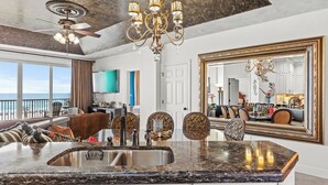 A spacious kitchen with a large island, a ceiling fan, and a chandelier. - Wave Whisperer: Family Beachfront Hideaway (Destin)