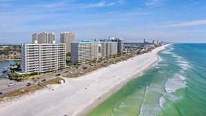 A coastal cityscape with a beachfront hotel, high-rise buildings, and a sandy beach. - Wave Whisperer: Family Beachfront Hideaway (Destin)