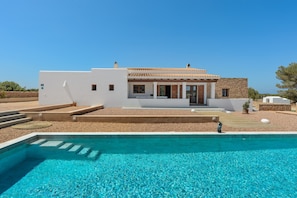 A modern house with a swimming pool, a patio, and a view of the sea. - Villa 'Casa S'Olibassa' with Private Pool, Wi-Fi and Air Conditioning (La Mola)