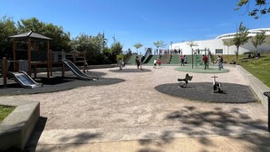 Un parc infantil amb tobogans, cadiraia i una estructura per escalar.