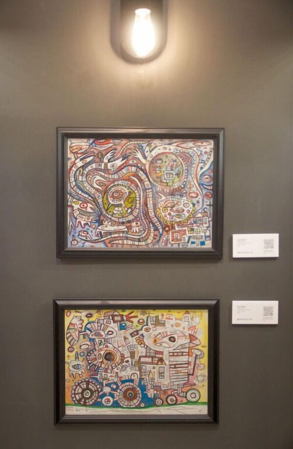Deux œuvres d’art encadrées sont accrochées au mur.