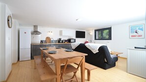 Eine moderne Küche mit Essbereich, einem schwarzen Sofa und einer Heizung.
